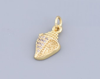 May include: Gold seashell charm with clear rhinestones. The charm is a detailed representation of a seashell with a textured surface.