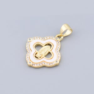 May include: Gold pendant with a white enamel four-leaf clover design and a small gold image of the Virgin Mary inside.