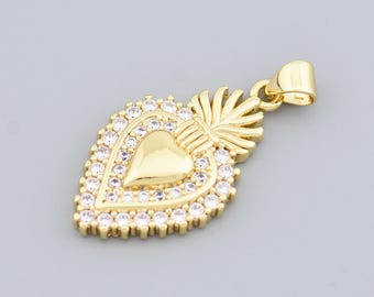 May include: A gold-colored pendant in the shape of a heart, adorned with clear crystals around the edges and a smaller heart in the center. The pendant has a bail for attaching to a chain. The design includes a flame-like element at the top.