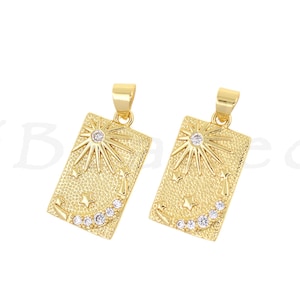 May include: Two gold-toned pendant charms with a sun and moon design. Each charm features a sun with rays and a crescent moon with small clear rhinestones.