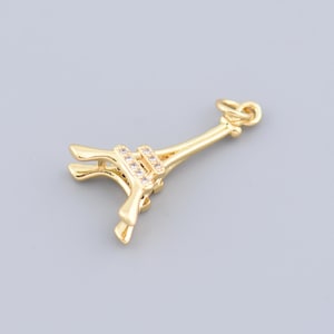 Puede incluir: Un charm de la Torre Eiffel de color dorado con pequeños adornos transparentes. El charm tiene un lazo en la parte superior para sujetarlo a un collar o pulsera. Es una réplica en miniatura del famoso monumento parisino.