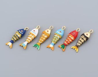 May include: Six colorful fish-shaped charms with gold-tone loops for jewelry making. Each charm features a different color scheme, including blue, white, orange, red, and black, with gold accents. The charms have detailed scales and fins.