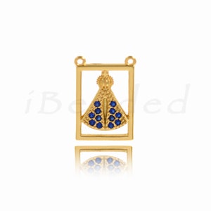 May include: Gold pendant charm with a blue crystal design in the shape of a dress. The charm is framed by a gold square.