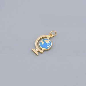 May include: A gold-coloured globe charm with a blue and white world map design. The charm is suspended from a small loop, and the globe is set within a gold-coloured stand.