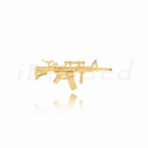 May include: A gold-colored rifle pendant with a scope and magazine. The pendant is highly detailed, with visible grooves and textures. The design is a miniature replica of a firearm, suitable for jewelry or crafting.