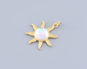 Puede incluir: Un amuleto de sol dorado con un centro de perla nacarada blanca. El sol tiene ocho rayos.