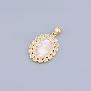 May include: A gold oval pendant with a white mother-of-pearl inlay surrounded by clear cubic zirconia stones.