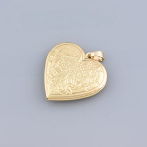 May include: A gold heart-shaped locket with an intricate floral design.