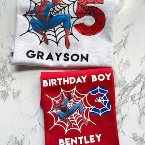 May include: Two red and white t-shirts with a Spiderman graphic and the text "Birthday Boy", "Grayson" and "Bentley".
