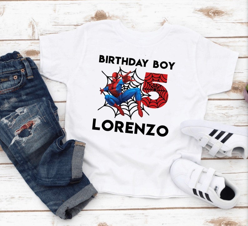 May include: White t-shirt with a red and blue Spiderman graphic, a red number 5, and the text "Birthday Boy" and "Lorenzo".