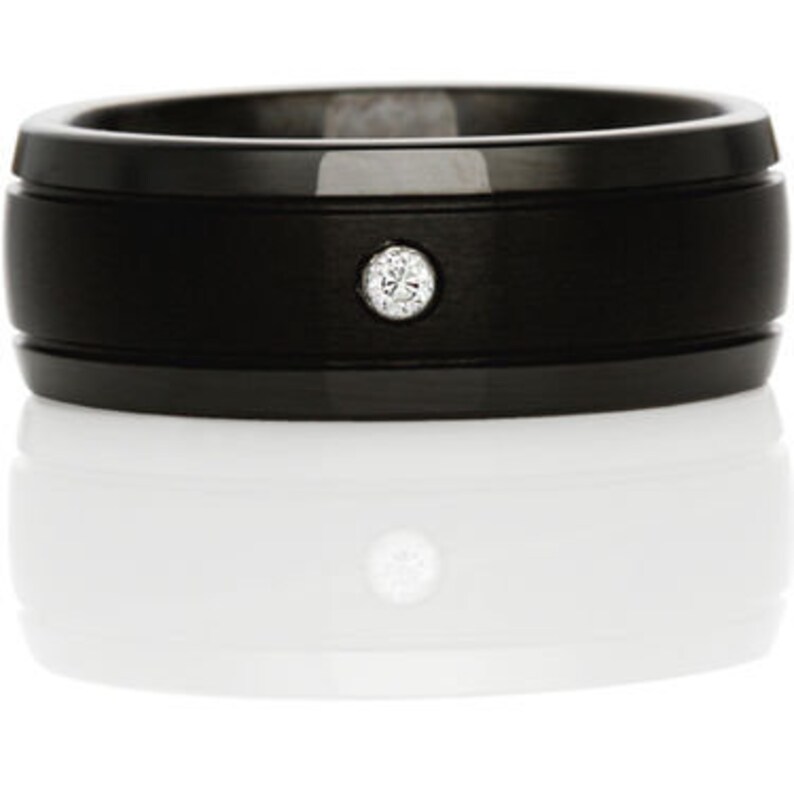May include: A black tungsten carbide ring with a single diamond set in the center.
