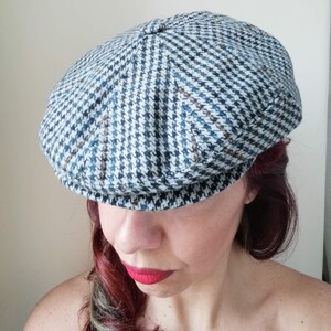 May include: A blue and white patterned newsboy cap with a slightly curved brim.