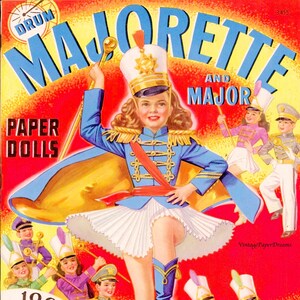 May include: Vintage paper doll cover titled "Majorette and Major." The illustration features a majorette in a blue uniform with a white skirt, surrounded by other marching band members. The text reads "100 Pieces to Play With."