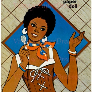 May include: Vintage "Lydia" paper doll cover art. The illustration features a woman with dark skin, wearing a brown corset, white earrings, and a scarf. The background is a diamond pattern with the text "LYDIA" and "paper doll".