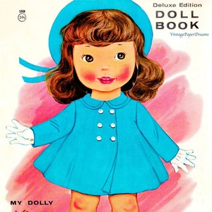May include: Vintage illustration of a doll wearing a blue coat, hat, and shoes. The doll has rosy cheeks, brown hair, and white gloves. Text on the cover reads "Deluxe Edition DOLL BOOK" and "MY DOLLY Kisses clothes pre-cut to push-out."