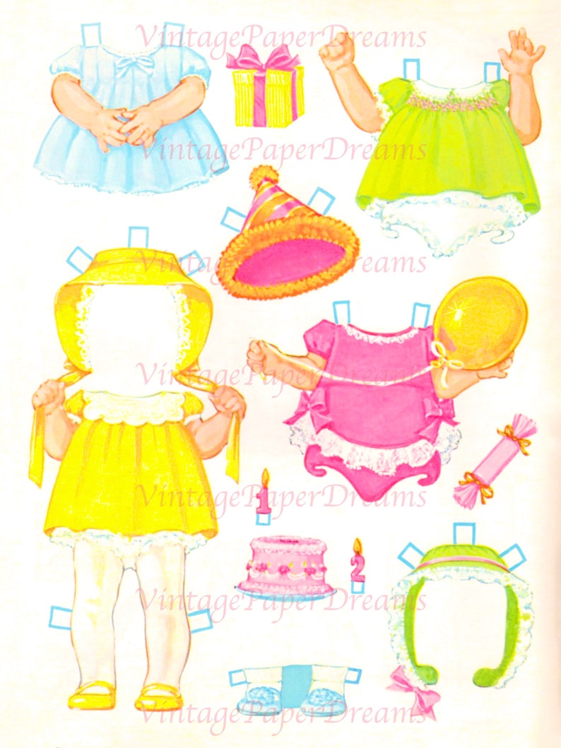 Op de afbeelding: Een vintage papieren poppenset met diverse outfits en accessoires. De set bevat een gele jurk, een blauwe jurk, een roze feesthoed, een verjaardagstaart en een cadeauverpakking. De tekst "Vintage Paper Dreams" is zichtbaar.