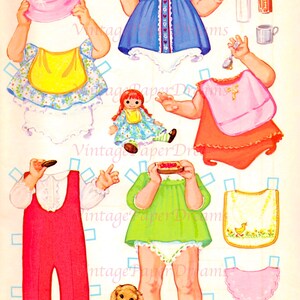 Op de afbeelding: Een vintage papieren poppenset met diverse outfits en accessoires. Inclusief een blauwe jurk, rode overall, een groen shirt, slabbetjes, een pop, een hond en een roze hoed. De tekst "Vintage Paper Dreams" en "Beth Ann" zijn zichtbaar.