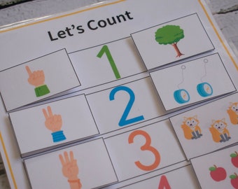 May include: A white card with the text "Let's Count" at the top. The card is divided into squares with numbers 1 through 4 and corresponding images. The images include a tree, two yo-yos, three foxes, and four apples.