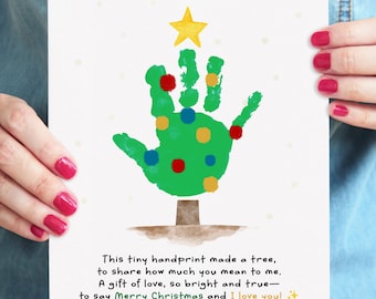May include: A white card with a green handprint Christmas tree design. The tree is decorated with colorful dots and topped with a yellow star. Text reads "Merry Christmas and I love you!"