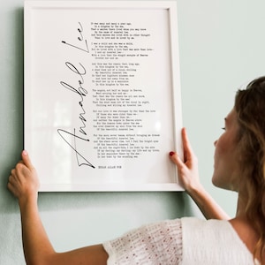 May include: A white framed print with a black and white poem titled "Annabel Lee" by Edgar Allan Poe. The poem is printed in a typewriter font.