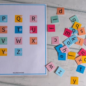 Op de afbeelding: Een kleurrijk alfabetkaart met letters P tot en met Z gedrukt op vierkanten in verschillende kleuren. De letters zijn in zwart gedrukt en er zijn kleine witte stippen op elk vierkant. Er zijn ook kleurrijke vierkanten met letters erop verspreid over een wit oppervlak.