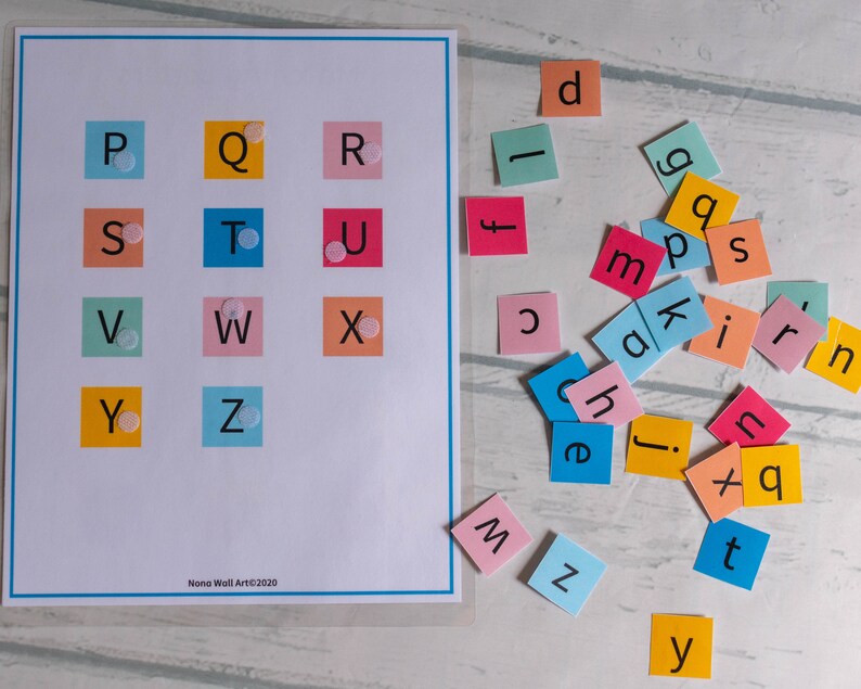 Op de afbeelding: Een kleurrijk alfabetkaart met letters P tot en met Z gedrukt op vierkanten in verschillende kleuren. De letters zijn in zwart gedrukt en er zijn kleine witte stippen op elk vierkant. Er zijn ook kleurrijke vierkanten met letters erop verspreid over een wit oppervlak.