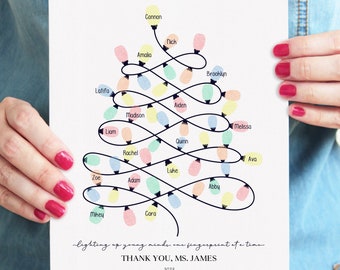 May include: A white print featuring a Christmas tree design made of colorful light bulbs, each with a name. The text reads "lighting up young minds, one fingerprint at a time" and "THANK YOU, MS. JAMES -2023-".
