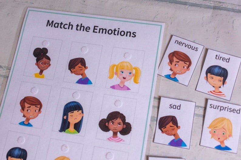 May include: A matching game for kids featuring illustrations of children with different facial expressions. The cards include words like "nervous", "tired", "sad", and "surprised".