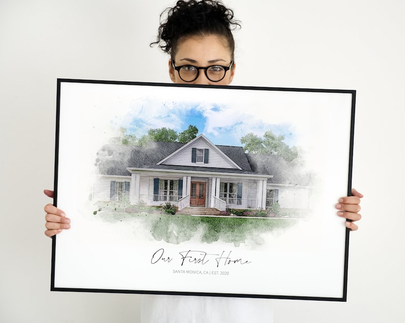 Puede incluir: Una impresi&oacute;n en acuarela enmarcada de una casa blanca con un marco negro. La casa tiene un tejado gris, contraventanas azules y una puerta marr&oacute;n. El texto "Our First Home" y "Santa Monica, CA | EST. 2020" est&aacute;n escritos en la impresi&oacute;n.
