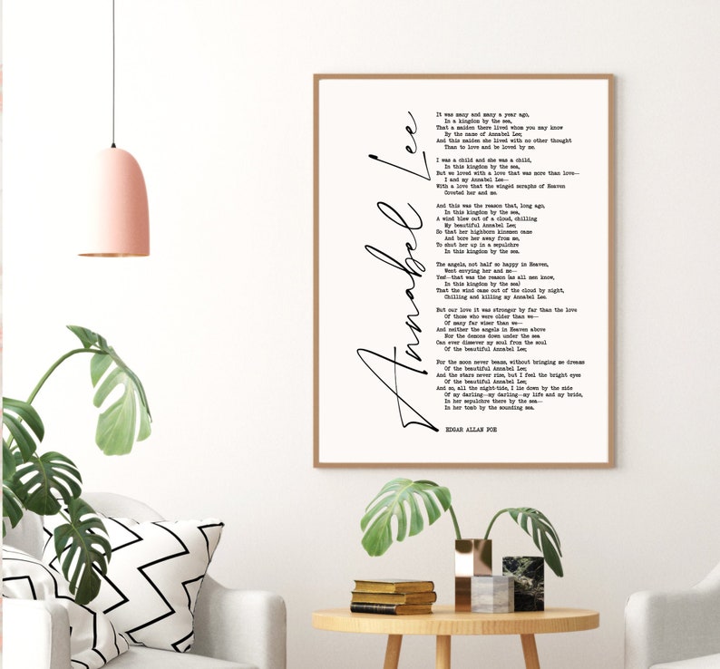 May include: A black and white printable wall art print featuring the poem "Annabel Lee" by Edgar Allan Poe. The poem is printed in a classic font and is framed in a simple black frame.