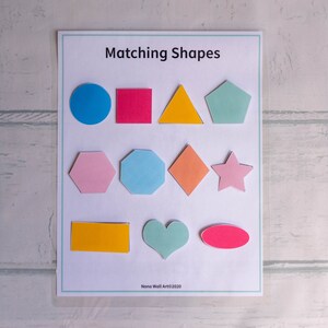 Op de afbeelding: Een printbaar werkblad voor het matchen van vormen. Het werkblad bevat een verscheidenheid aan vormen in verschillende kleuren, waaronder een cirkel, een vierkant, een driehoek, een vijfhoek, een zeshoek, een ruit, een ster, een rechthoek, een hart en een ovaal. De titel van het werkblad is "Matching Shapes".