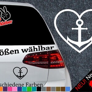 Op de afbeelding: Witte vinyl sticker van een anker in een hartvorm. De sticker is te zien op de achterruit van een auto. De tekst "6 Größen wählbar" en "21 verschiedene Farben" is zichtbaar op de auto. De tekst "NEU! Neonfarben" is zichtbaar aan de rechterkant van de afbeelding.