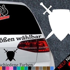 Puede incluir: Un coche blanco con una pegatina en blanco y negro de un escudo con dos espadas en la ventana trasera. La pegatina dice "6 Größen wählbar" y "21 verschiedene Farben".