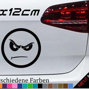 以下が含まれることがあります： 白い車の「12x12cm」と「21 verschiedene Farben」のテキストが付いた、黒と白の怒った顔のステッカー。ステッカーは12センチメートル×12センチメートルです。