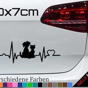 Peut inclure: Autocollant en vinyle noir représentant un chien et un chat avec un rythme cardiaque et un cœur. L'autocollant mesure 20 cm sur 7 cm et est disponible en 21 couleurs. Le texte "NEU! Neonfarben" se trouve dans le coin inférieur droit de l'image.