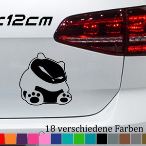 Puede incluir: Una pegatina de un animal de dibujos animados en blanco y negro con el texto "12x12cm" encima. La pegatina está en la parte trasera de un coche blanco. El texto "18 verschiedene Farben" está debajo de la pegatina. Una fila de 18 cuadrados de colores está debajo del texto.