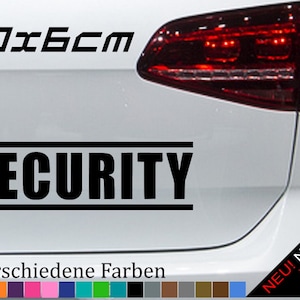 Könnte beinhalten: Schwarz-weißer Aufkleber mit dem Schriftzug "SECURITY" in fetten Buchstaben und schwarzem Rand. Der Aufkleber ist 20 cm x 6 cm groß und wird auf der Rückseite eines weißen Autos gezeigt. Der Text "21 verschiedene Farben" befindet sich unter dem Aufkleber, und darunter befindet sich eine Reihe von 21 Farbmustern.