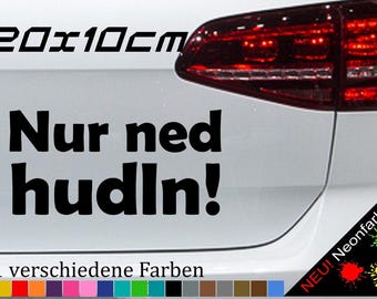 May include: A black and white sticker with the text "Nur ned hudln!" and the size "20 x 10 cm". The sticker is on the back of a white car. The text "21 verschiedene Farben" is below the sticker. There are 21 color swatches below the text.