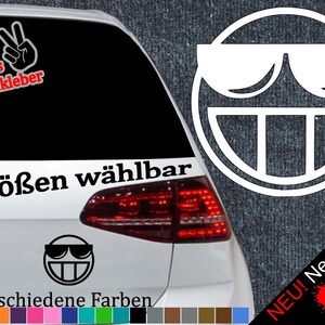 以下が含まれることがあります： 白い笑顔のステッカーにサングラス、大きく開いた口、そして突き出た舌が描かれています。ステッカーは白い車に貼られており、黒い文字で「6 Größen wählbar」と「21 verschiedene Farben」と書かれています。リアウィンドウには赤い文字で「+ Gratis Testaufkleber」と書かれています。ステッカーは6つのサイズと21色のカラーバリエーションがあります。