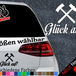 May include: A black and white sticker with two crossed pickaxes and the text "Glück auf!" in white. The sticker is on a car with a red taillight. The text "6 Größen wählbar" and "21 verschiedene Farben" are also visible on the car. The sticker is available in multiple sizes and colours.