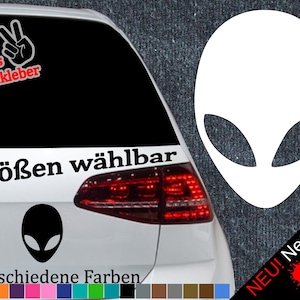 Könnte beinhalten: Ein weißes Auto mit einem schwarzen Alienkopf-Aufkleber auf der Heckscheibe. Der Aufkleber lautet "6 Größen wählbar" und "21 verschiedene Farben". Außerdem gibt es Aufkleber mit den Worten "+ Gratis Testaufkleber" und "NEU! Neonfarben".