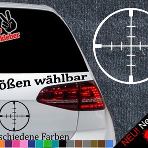 Könnte beinhalten: Ein weißes Auto mit einem schwarz-weißen Zielscheiben-Aufkleber an der Heckscheibe. Der Aufkleber lautet "6 Größen wählbar" und "21 verschiedene Farben". Außerdem befindet sich ein Aufkleber mit einem Peace-Zeichen und dem Text "+ Gratis Testaufkleber".