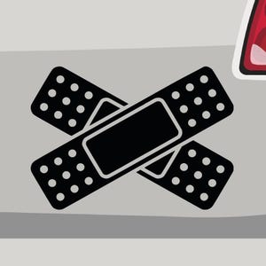 May include: Two black adhesive bandages crossed over each other. The bandages have a dotted pattern and a black rectangular shape in the center.