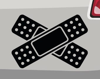 Puede incluir: Dos vendas adhesivas negras cruzadas una sobre la otra. Las vendas tienen un patrón de puntos y una forma rectangular negra en el centro.