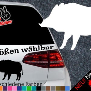 Könnte beinhalten: Ein weißes Auto mit einem schwarz-weißen Wildschwein-Aufkleber auf der Heckscheibe. Der Aufkleber lautet "6 Größen wählbar" und "21 verschiedene Farben".