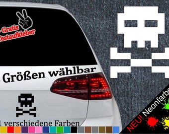 May include: A white car with a black and white pixelated skull and crossbones sticker on the back window. The sticker says "6 Größen wählbar" and "21 verschiedene Farben". There is also a sticker with a peace sign and the text "+ Gratis Testaufkleber".
