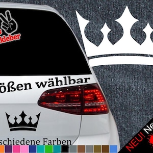 Puede incluir: Una pegatina de corona en blanco y negro con el texto "6 Größen wählbar" y "21 verschiedene Farben". La pegatina está en la parte trasera de un coche plateado.