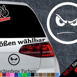 以下が含まれることがあります： 白い車の後ろの窓に、黒と白の怒った顔のステッカーが貼ってあります。ステッカーには「6 Größen wählbar」と「21 verschiedene Farben」と書かれています。画像の右側には、赤、黄、緑の飛び散った塗料のデザインがあり、「NEU! Neonfarben」というテキストが書かれています。