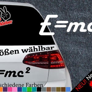 May include: A white car with a black and white sticker that says "E=mc2" and "6 Größen wählbar". The sticker is on the back window of the car. There is also a smaller sticker that says "+ Gratis Testaufkleber" and a peace sign. The car has a red taillight and a black bumper. There is a text overlay that says "NEU! Neonfarben" with three colored paint splatters.