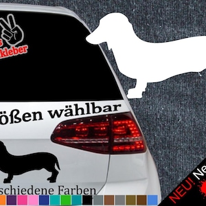 May include: A white silhouette of a dachshund dog with the text "6 Größen wählbar" and "21 verschiedene Farben" below. The image is on a black car with a red taillight. The text "NEU! Neonfarben" is in the lower right corner with three colored paint splatters.